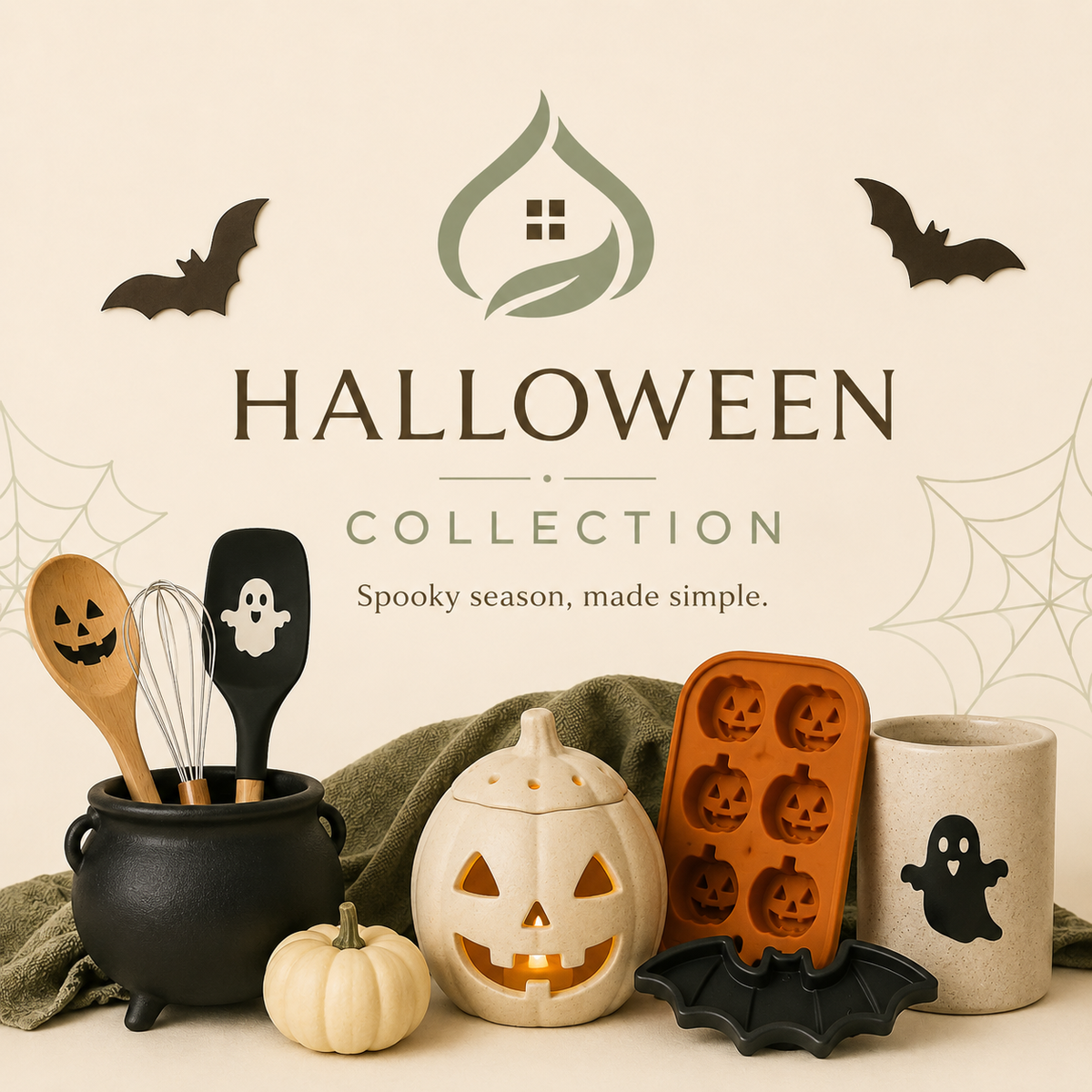 Halloween-themed kitchen collection set featuring a black cauldron with wooden utensils, a carved jack-o'-lantern, an orange silicone mold, a small pumpkin, a ghost mug, and bat decorations, arranged on a beige background with 'HALLOWEEN COLLECTION' text.